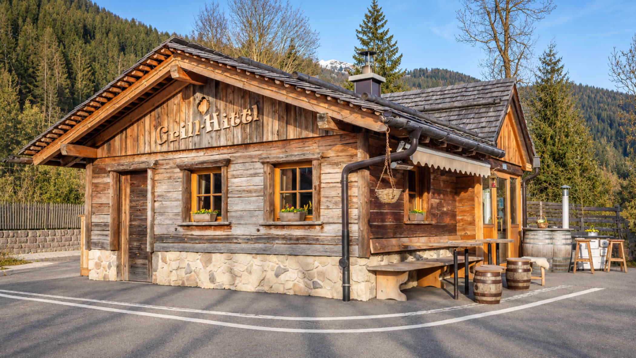 Kleines Holzgebäude mit der Aufschrift Grill-Hittl in einer Berglandschaft. - S'Grillhittl